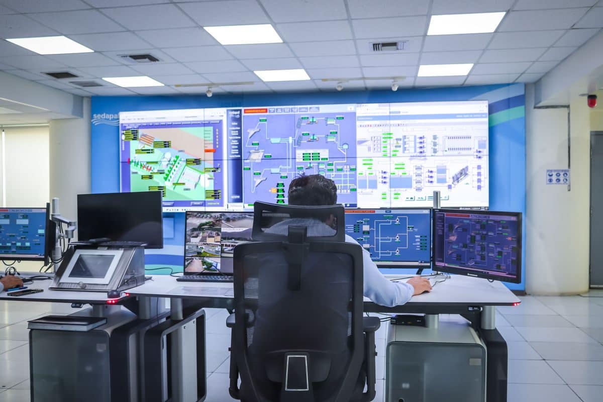 Sala de controle SCADA/OT — monitoramento em tempo real dos ativos industriais